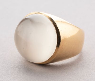 a close up of a gold ring with a white stone on it