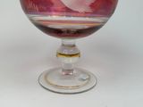 a wine glass with a bird on it on a table