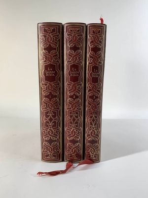 trois livres rouges superposés sur une surface blanche