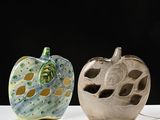 two apple shaped vases sitting on a white table