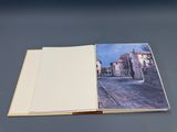 an open book with a picture of a street in the middle of it