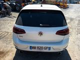 the rear end of a white car parked in a parking lot