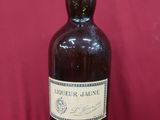 une vieille bouteille d'alcool posée sur une table rouge