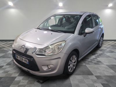la petite voiture argentée est garée sur un carrelage à carreaux