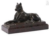 statue of a dog laying down on a marble base on a white background