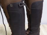 pair of brown boots with laces on them sitting on a wooden floor