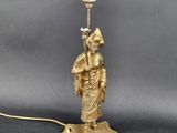 une figurine ancienne en laiton représentant un homme tenant une lampe