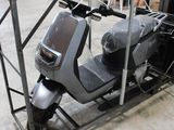 un scooter posé sur un chariot dans un garage