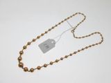 a close up of a gold necklace with a tag on it