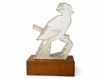 sculpture représentant un oiseau perché sur une branche, posée sur un socle en bois
