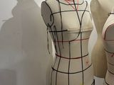 two mannequins are lined up on a stand in a room