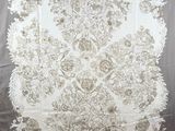 a close up of a white and grey floral design on a gray background