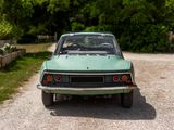 a green car that is parked on the side of the road