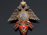 an image of a gold and red broochle with an eagle on it