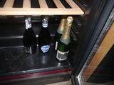 bottles of wine are sitting in a wine cooler with wooden shelves