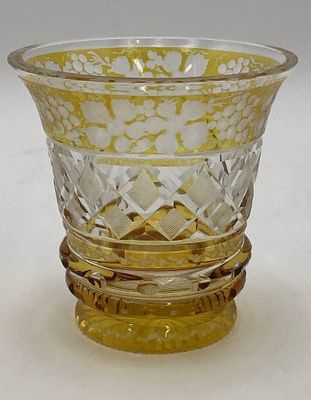 un vase en verre jaune posé sur une table blanche