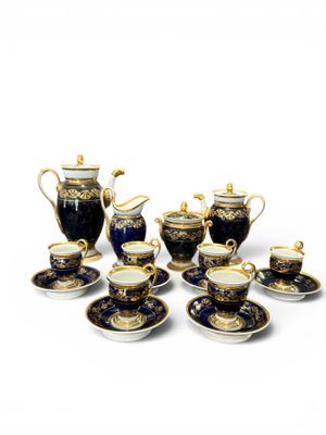 a group of blue and gold tea and coffee cups and saucers