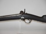 a close up of a rifle on a stand on a white surface