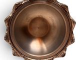 a close up of a metal bowl on a white surface