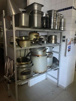de nombreuses casseroles et poêles sur les étagères de la cuisine