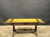 a wooden table with a yellow top sitting on top of a wooden floor