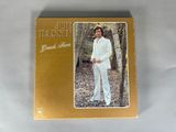 the cover of the album, featuring a picture of a man in a white suit standing next to a tree