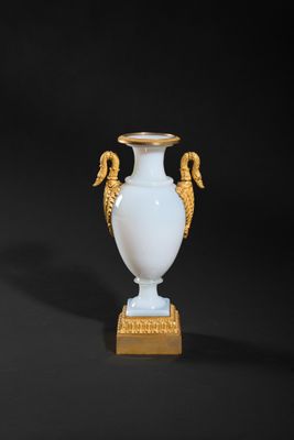 pair of white and gold vases with seahorses on a stand