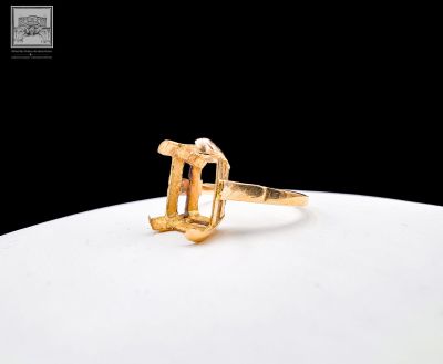a close up of a gold ring on a plate with a black background