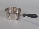 a silver cup with a black handle on a white table