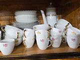 de nombreuses tasses et soucoupes posées sur une étagère dans un vaisselier