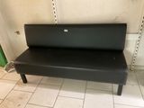 a black bench that is sitting on a tiled floor