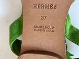 the heel of a woman ' s shoe with a green ribbon around it