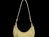 un gros plan d'un sac à main beige sur fond noir