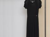 La robe noire est suspendue à un portant dans la pièce.
