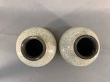 pair of white vases with cracky glaze on them sitting on a table
