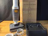 une boîte contenant un aspirateur et une brosse, posée sur une table