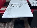 a white table with red cushions and a black and white bench