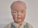 a small doll that is wearing overalls and a white shirt