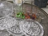 a table with glass plates on it and a vase with flowers in it