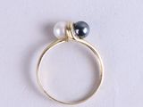 a close up of a gold ring with two pearls on it