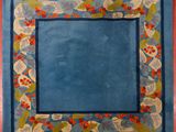 a picture of a rug with a blue border and red berries on it