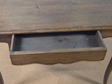 a small wooden table with a drawer on it
