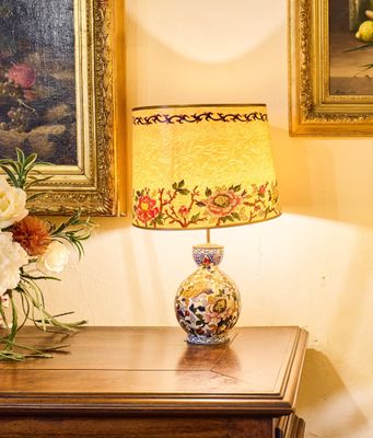 un vase de fleurs posé sur une table à côté d'une lampe