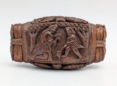 un bracelet ancien en bois sculpté représentant un homme et une femme dans une forêt