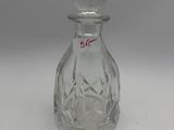 an old fashioned glass bottle with a stopper on a white surface