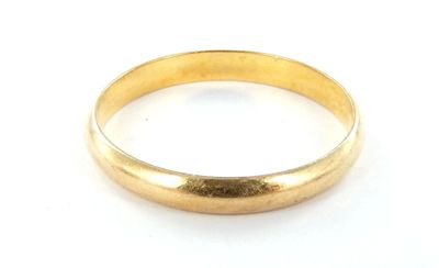 gros plan d'une bague en or sur une surface blanche