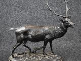 a statue of a deer that is standing on a base