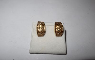 a pair of gold toned earrings on a white surface