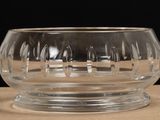 a clear glass bowl on a table with a black background