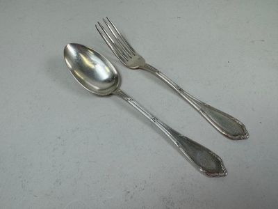 two spoons and a fork sitting on a table
